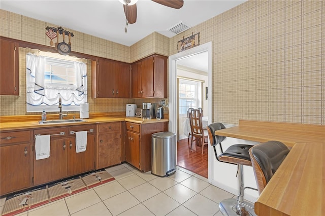 kitchen with ceiling fan, light tile patterned floors, and sink