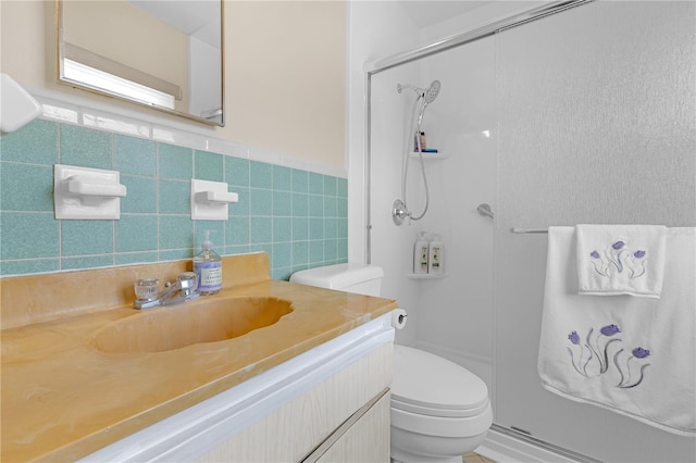 bathroom featuring toilet, vanity, tile walls, and walk in shower