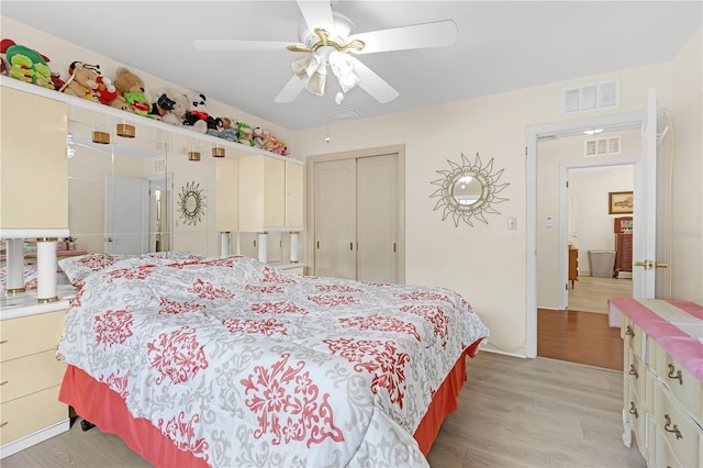 bedroom with ceiling fan, light hardwood / wood-style floors, and a closet