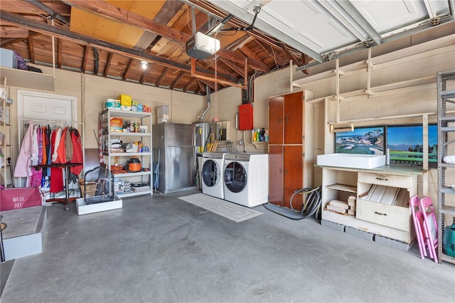 garage with washing machine and dryer, a garage door opener, and stainless steel fridge