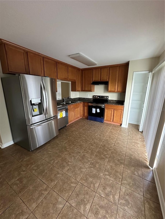 kitchen with black electric range oven, dishwasher, dark tile patterned flooring, sink, and stainless steel fridge