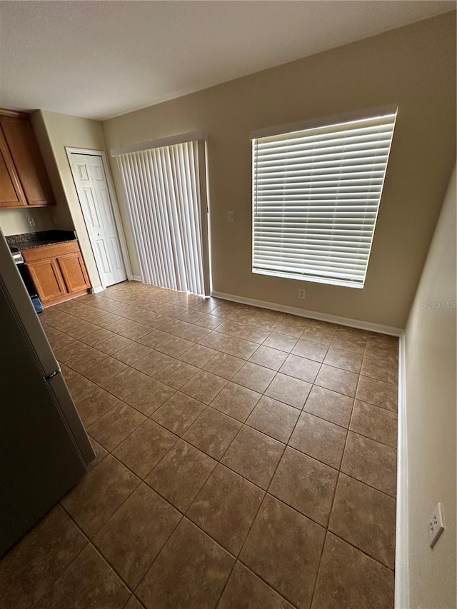 unfurnished living room with dark tile patterned floors