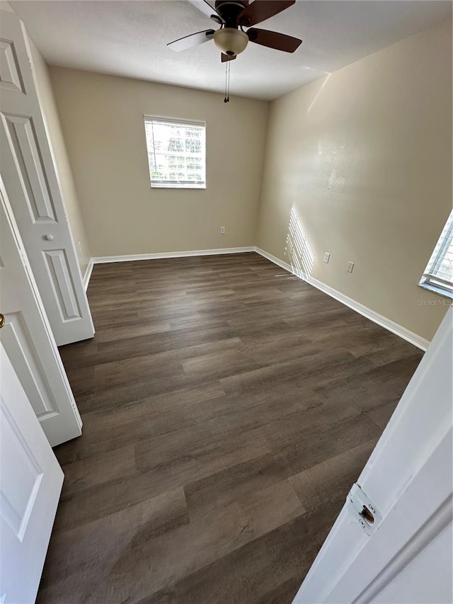 spare room featuring dark wood-type flooring and ceiling fan