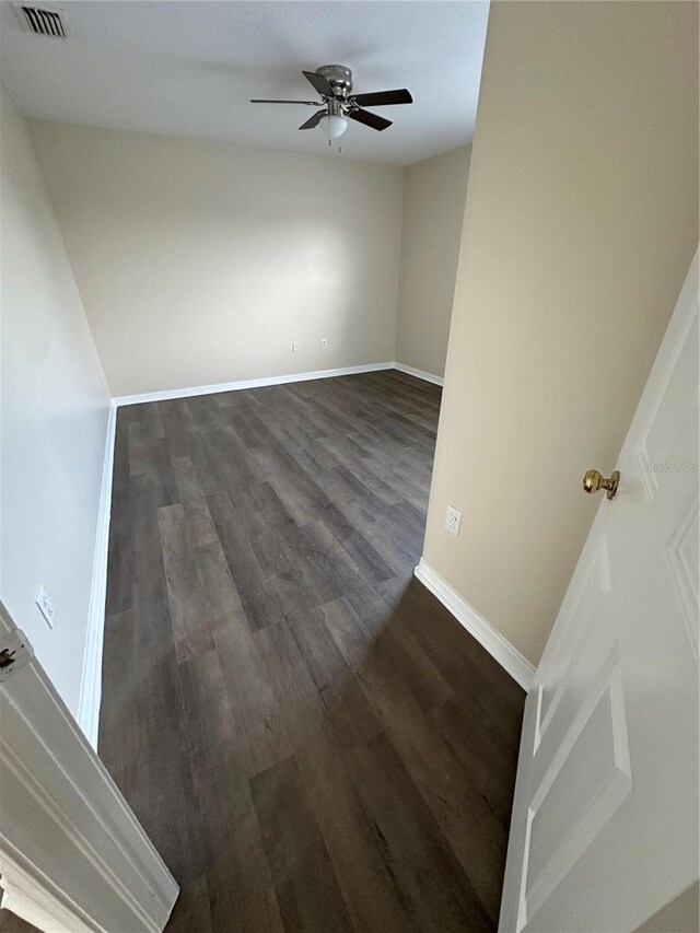 spare room featuring ceiling fan and dark wood-type flooring