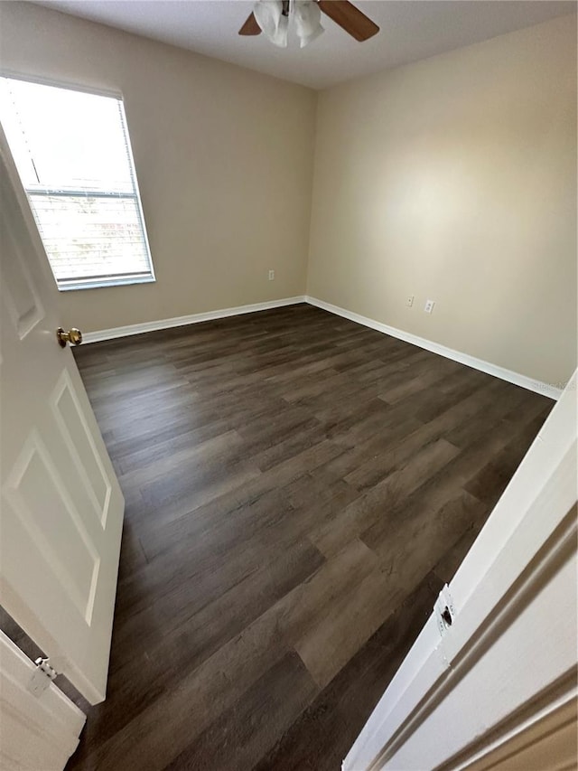 empty room with ceiling fan and dark hardwood / wood-style floors