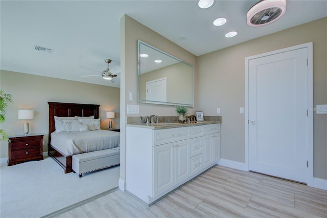 bedroom with light carpet, sink, and ceiling fan