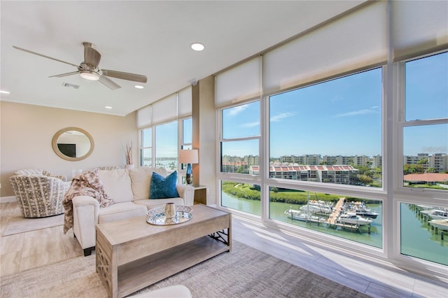 living room featuring a water view, plenty of natural light, and floor to ceiling windows