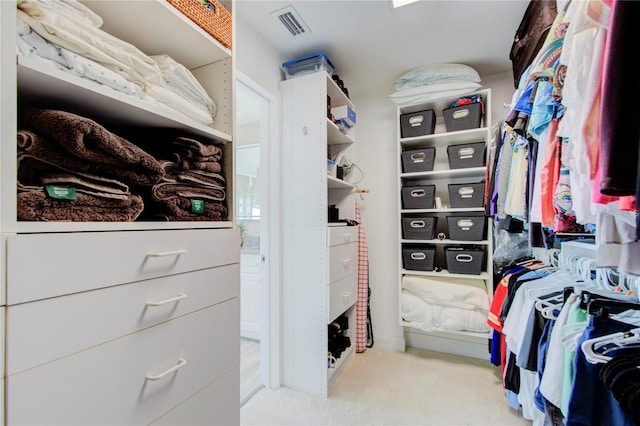 walk in closet featuring light carpet