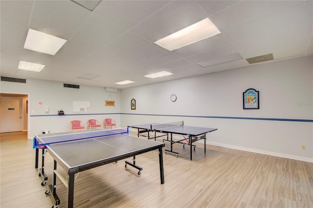 recreation room featuring a paneled ceiling and light hardwood / wood-style floors