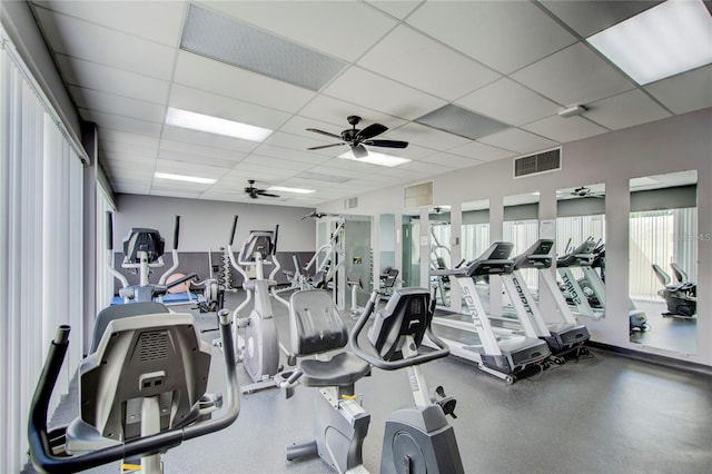 workout area with a paneled ceiling and ceiling fan