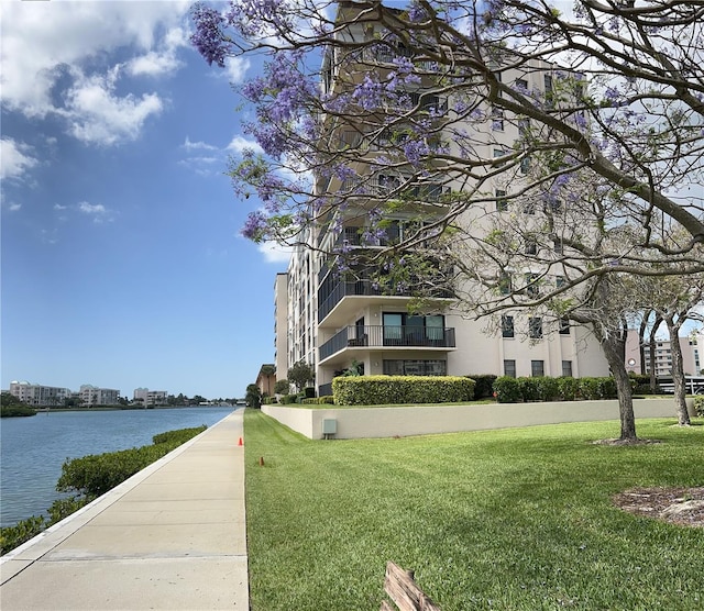 view of property's community featuring a water view and a lawn