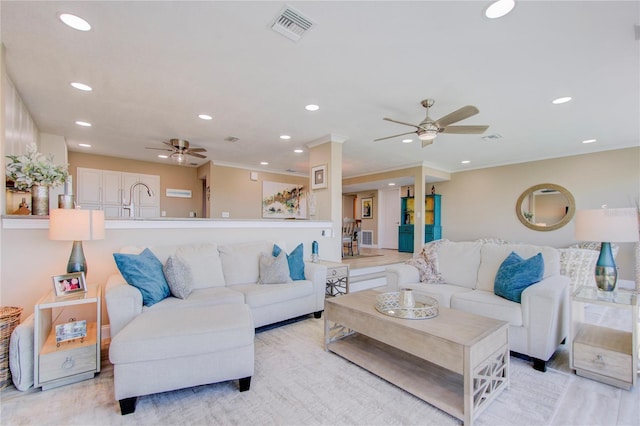 living room with ornamental molding, light hardwood / wood-style floors, and ceiling fan