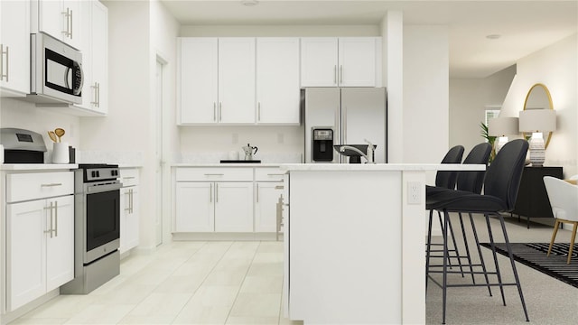 kitchen featuring a kitchen island with sink, white cabinets, stainless steel range, and refrigerator with ice dispenser