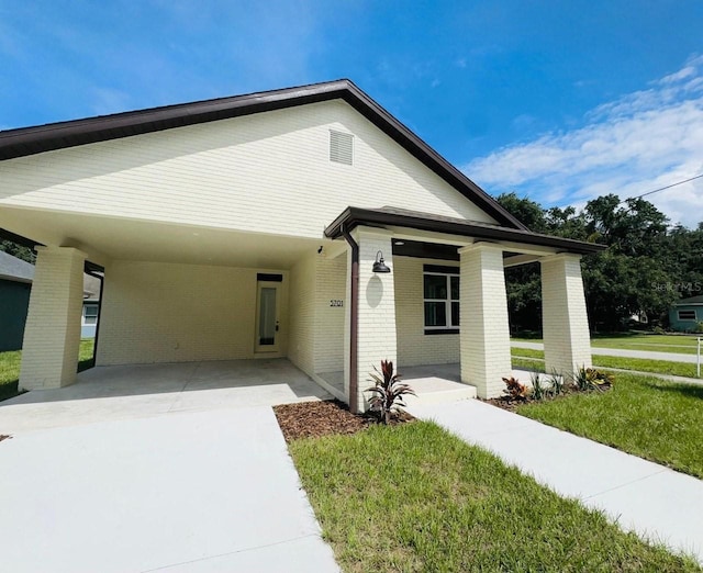 view of front of property featuring a front lawn and a carport