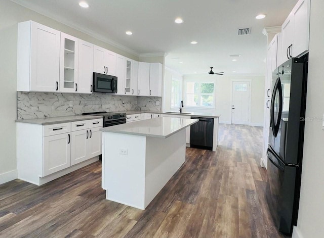 kitchen featuring a center island, white cabinets, dark hardwood / wood-style floors, and black appliances