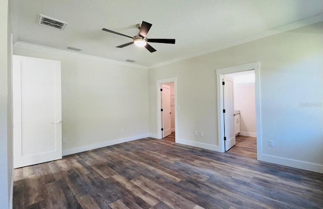 unfurnished bedroom featuring crown molding, dark wood-type flooring, and ensuite bathroom