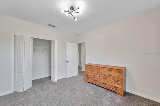 carpeted bedroom featuring a closet and a textured ceiling