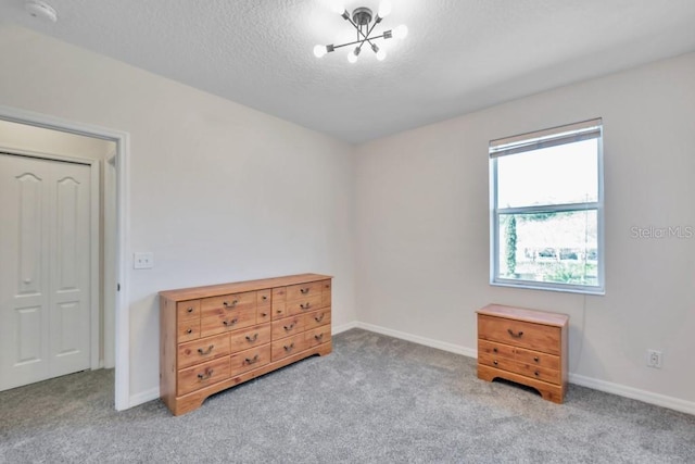 carpeted bedroom with a closet and an inviting chandelier