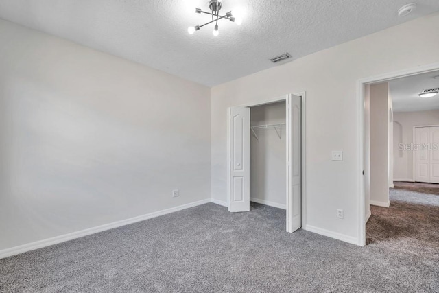 unfurnished bedroom with a textured ceiling, a closet, and carpet flooring