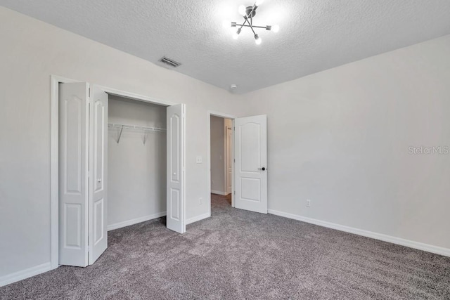 unfurnished bedroom with a textured ceiling, a closet, and carpet