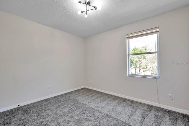 carpeted empty room featuring a textured ceiling