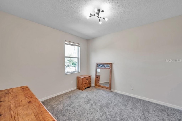 carpeted spare room featuring a textured ceiling