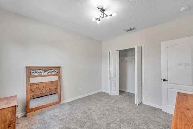 carpeted bedroom with a closet and a textured ceiling