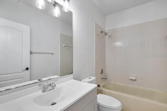 full bathroom with toilet, vanity, and tiled shower / bath