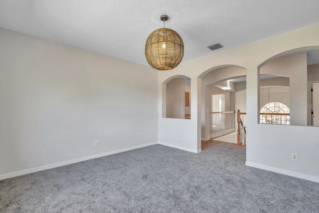 carpeted empty room with a textured ceiling