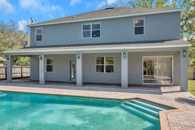 back of house with a fenced in pool and a patio