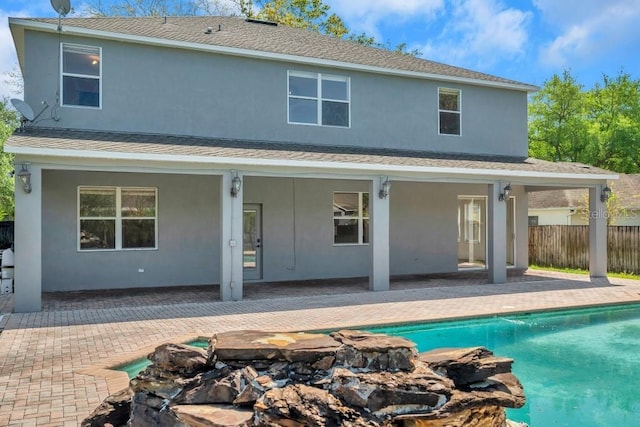 rear view of house featuring a patio area and a fenced in pool