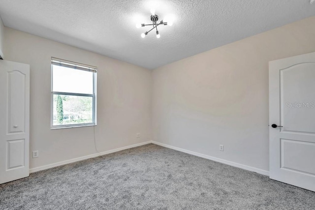 unfurnished room featuring carpet and a textured ceiling