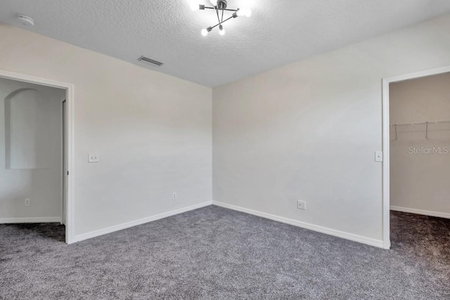 carpeted spare room featuring a textured ceiling