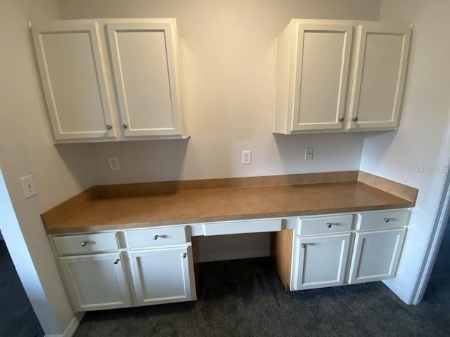 kitchen with white cabinetry and built in desk