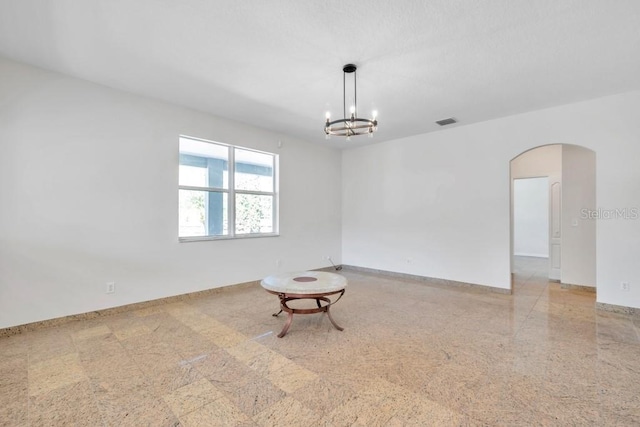 empty room featuring an inviting chandelier