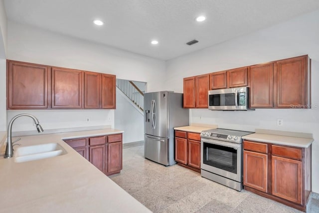 kitchen with sink, a high ceiling, and stainless steel appliances