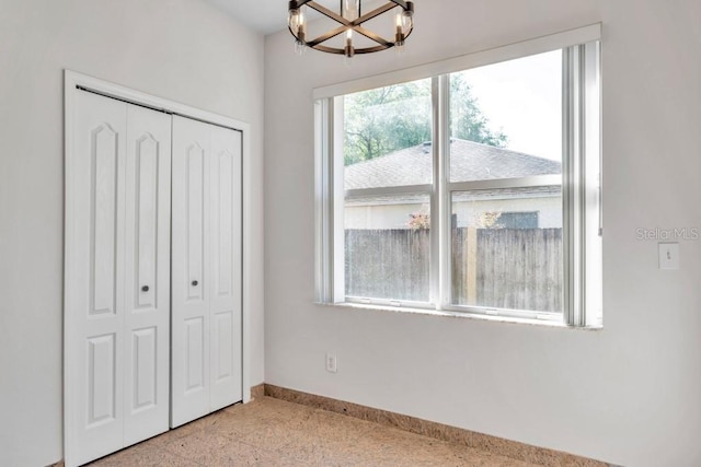 unfurnished bedroom with a closet and a chandelier