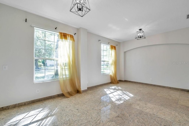 empty room featuring an inviting chandelier