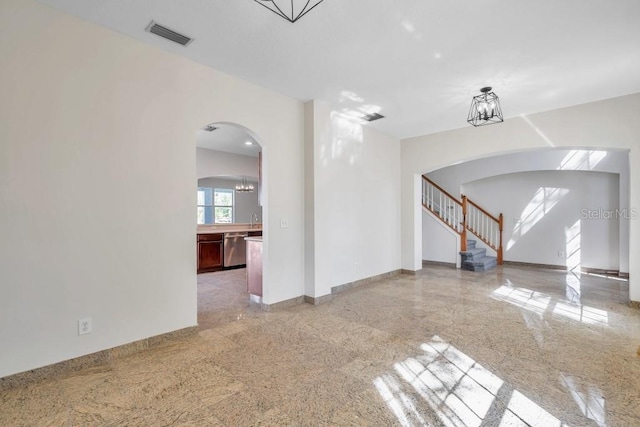 unfurnished living room with an inviting chandelier