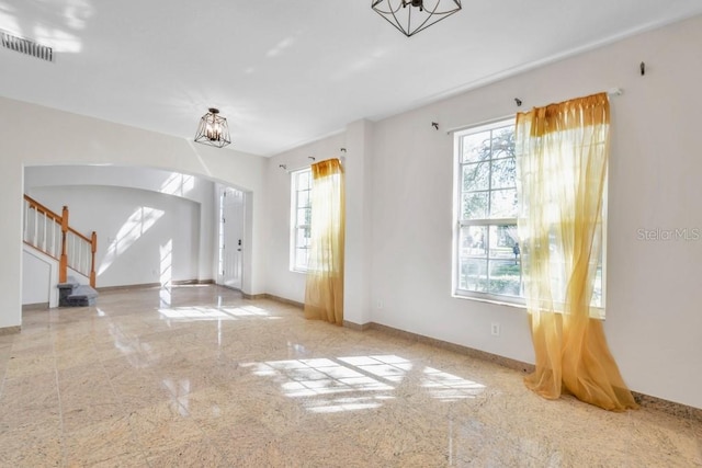 unfurnished living room with an inviting chandelier