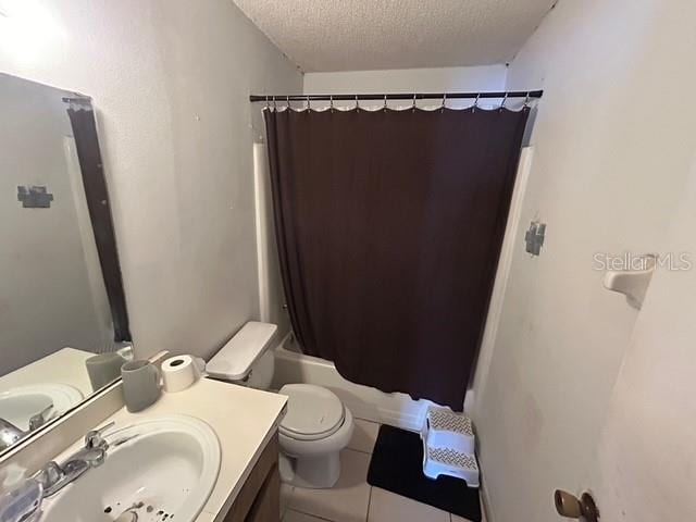 full bathroom featuring tile patterned flooring, vanity, a textured ceiling, toilet, and shower / bath combo with shower curtain