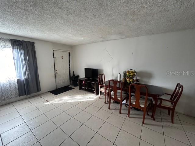 dining area with a textured ceiling and light tile patterned floors