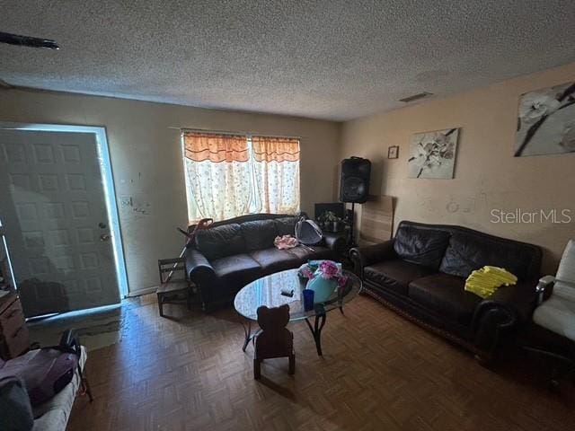 living room featuring parquet flooring and a textured ceiling