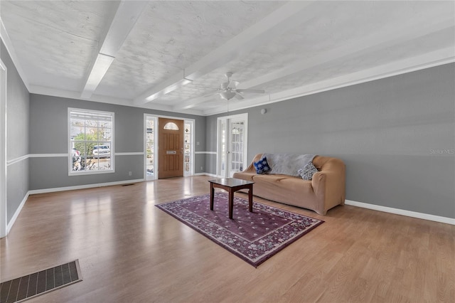 living room featuring light wood-type flooring, beam ceiling, and ceiling fan