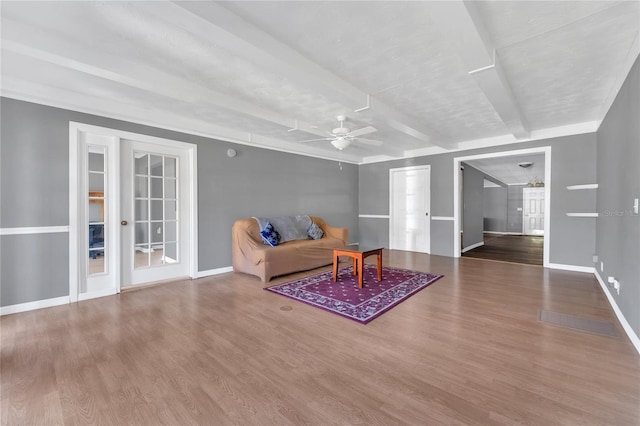 living room with hardwood / wood-style flooring, ceiling fan, and beamed ceiling