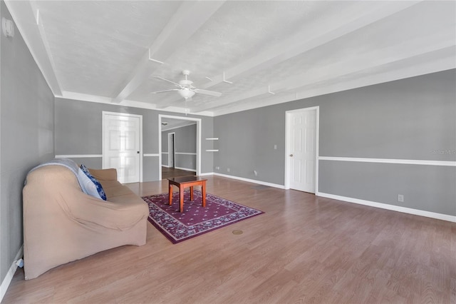 living room featuring ceiling fan, wood-type flooring, and beam ceiling