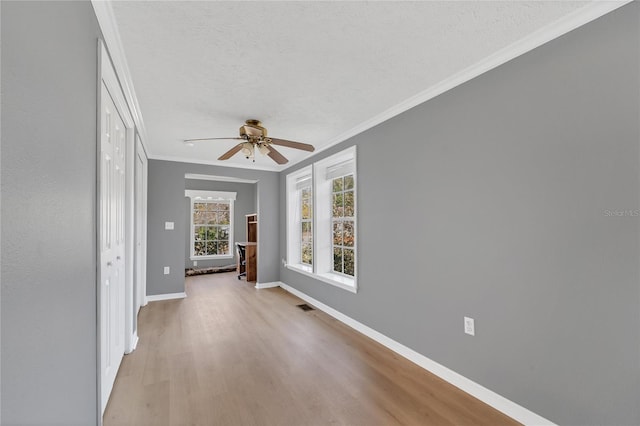 interior space featuring light hardwood / wood-style floors, a textured ceiling, ceiling fan, and ornamental molding