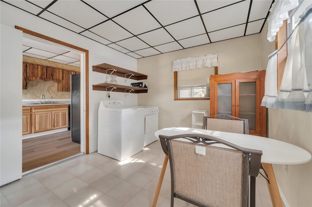 interior space featuring sink, light tile patterned floors, and washing machine and clothes dryer