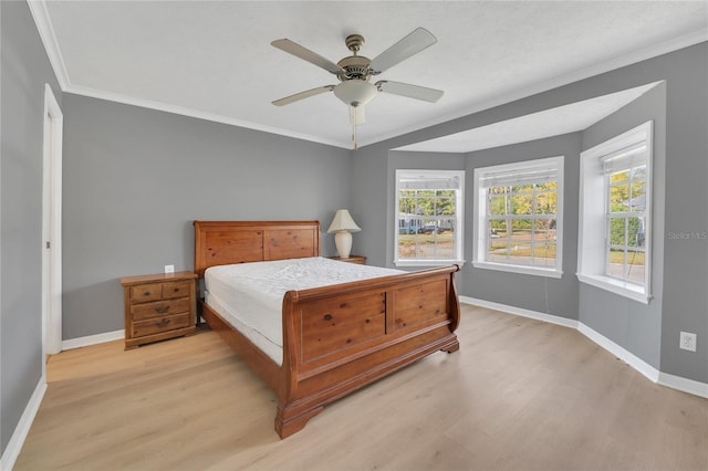 bedroom with light wood-type flooring, ceiling fan, and ornamental molding