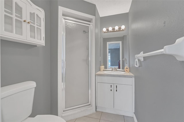 bathroom featuring a textured ceiling, tile patterned floors, vanity, toilet, and a shower with shower door